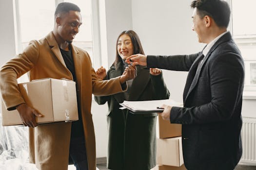 A diverse couple joyfully receives keys to their new home from a real estate agent.