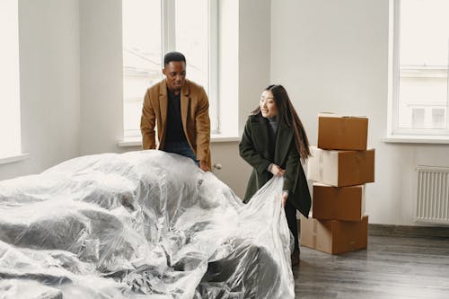 Free Man and Woman Unpacking in New Home Stock Photo