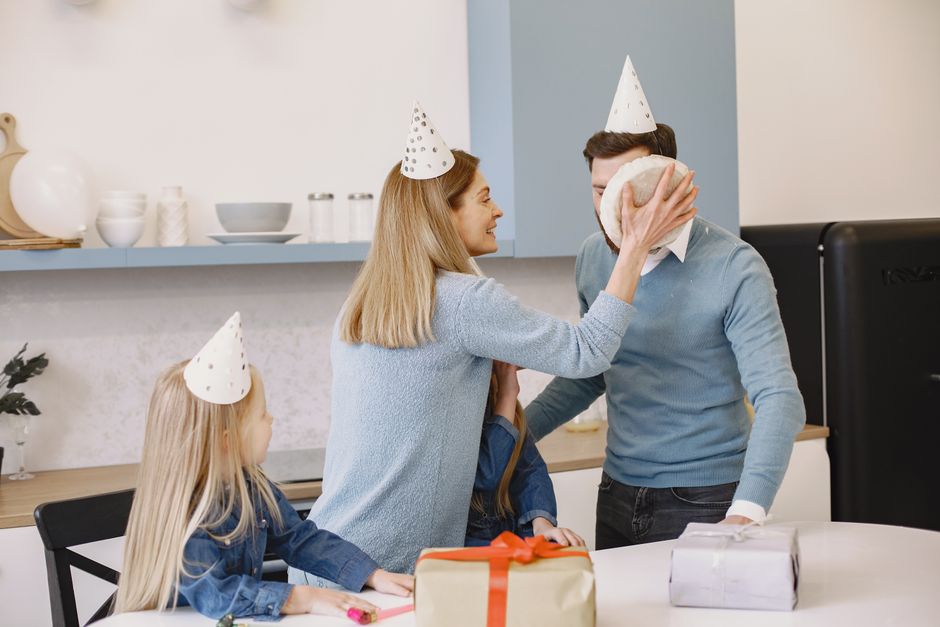 how to care for engraved gifts - Family enjoying a birthday celebration with fun cake prank and gifts indoors.