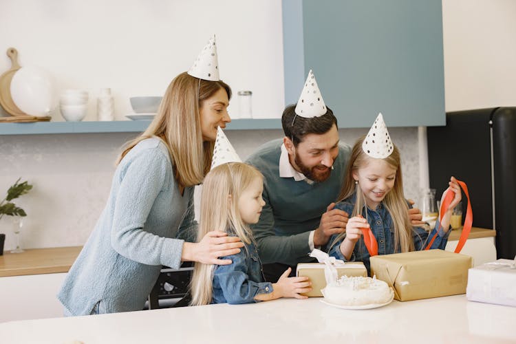 A Girl Opening A Gift With Her Family