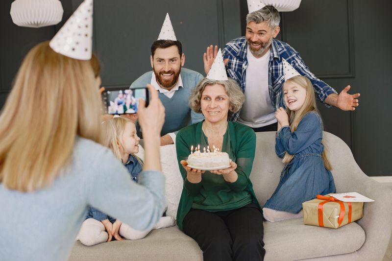 Grandmother holding a birthday cake surrounded by family by Gustavo Fring on Pexels
