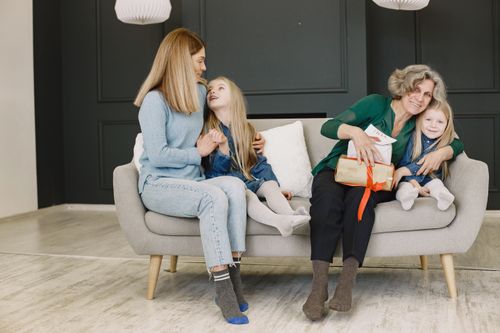 Free Grandmother and family share a loving moment indoors on a sofa. Stock Photo