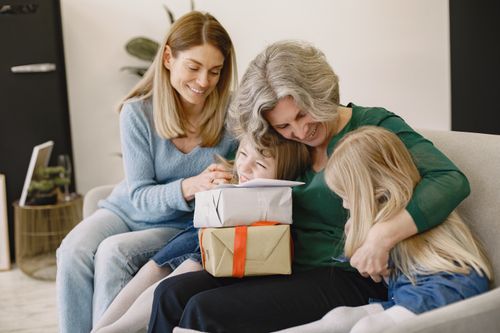 Free A happy family sharing gifts and smiles indoors, capturing moments of togetherness and joy. Stock Photo