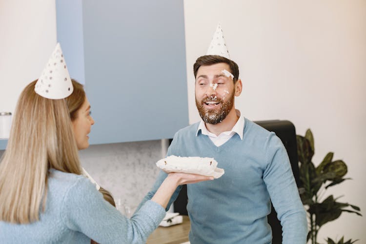 Smiling Woman And Man In Birthday Hats