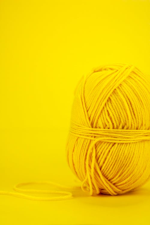 Skein of colorful yarn against yellow background