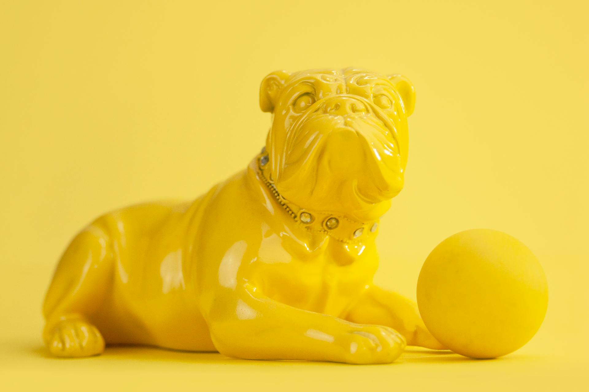 Figurine of French bulldog and ball in yellow color