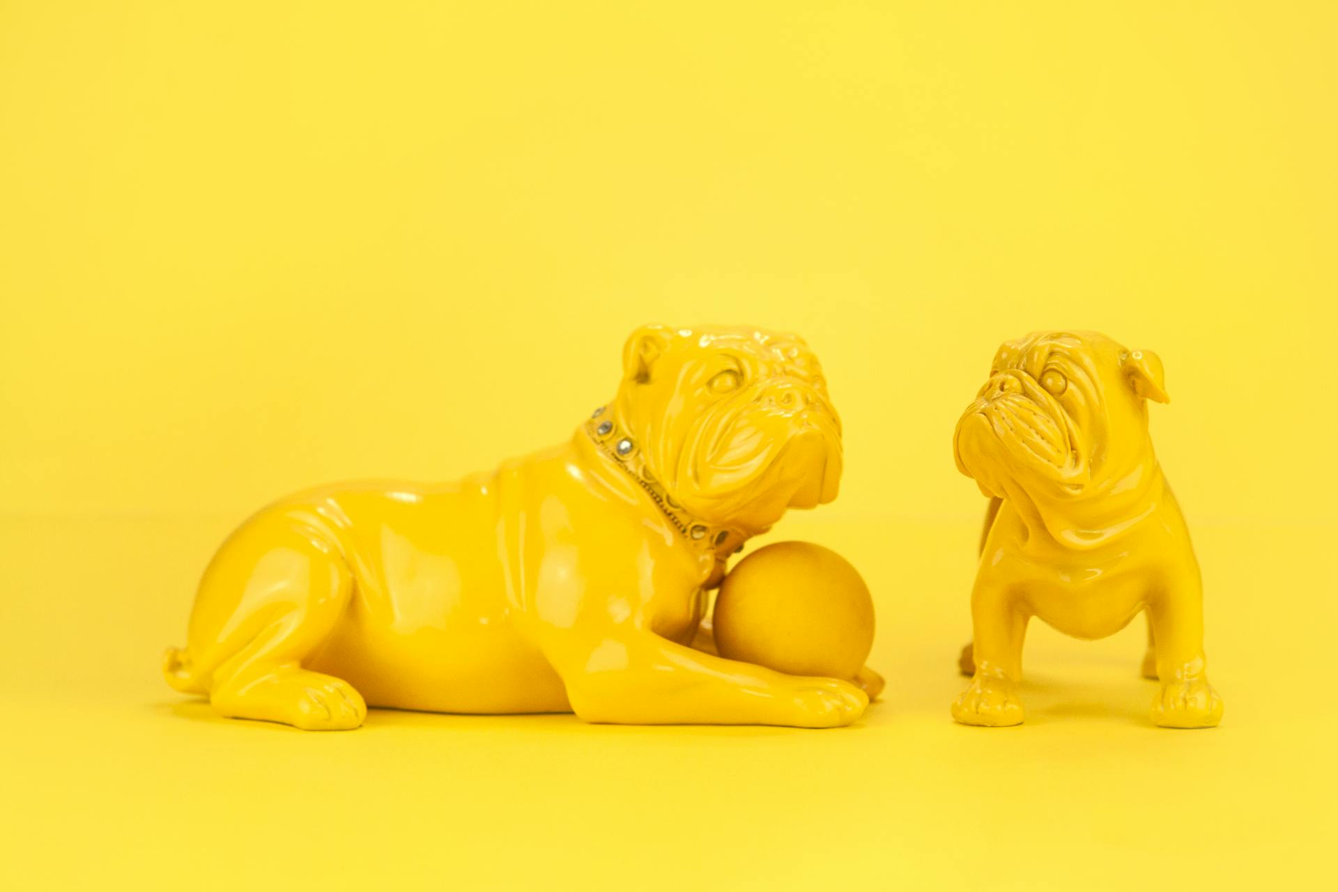 Small yellow statuettes of bulldogs with ball