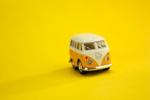 Little toy car on yellow background