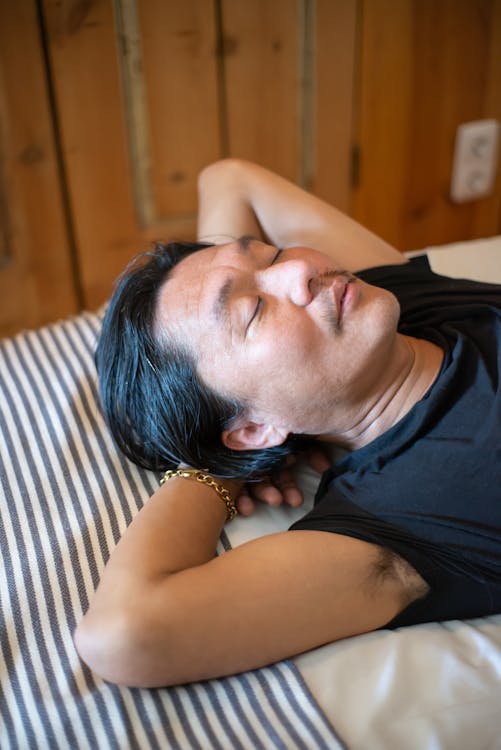 Close-Up Photo of a Man in a Black Shirt Sleeping