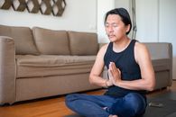 Man in Blue Tank Top and Blue Pants Sitting on Brown Couch