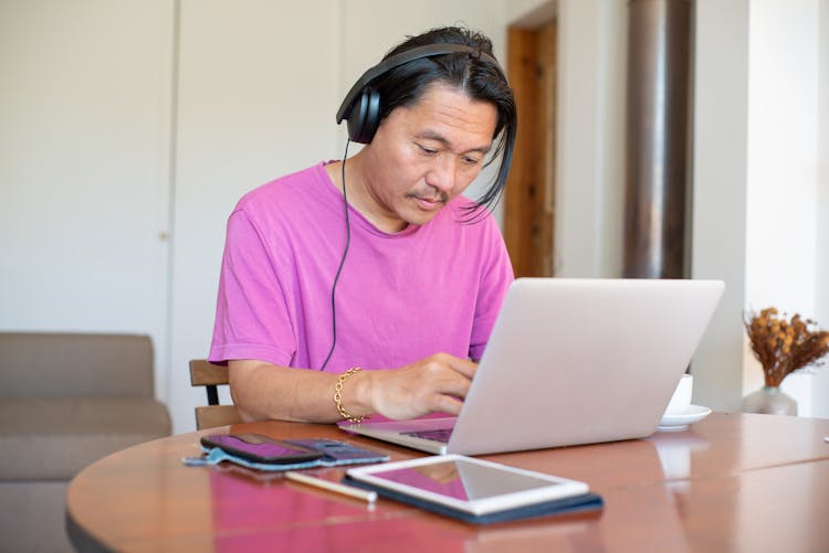 Man Wearing Headset Typing On His Laptop