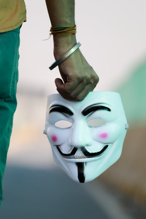 Free Selective Focus Photo of a Person's Hand Holding a White Mask Stock Photo