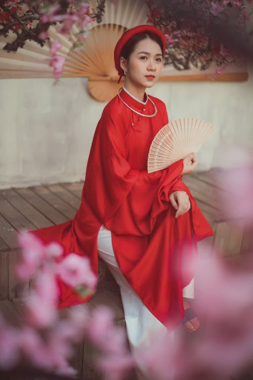Free Beautiful Woman in Red Clothes Holding a Hand Fan Stock Photo