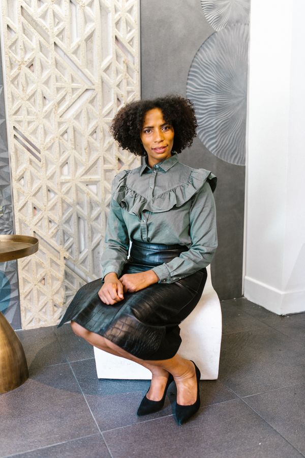 Woman in a dark green satin blouse and black pencil skirt