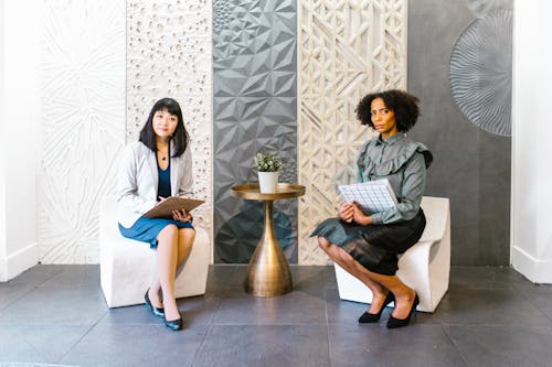 Free Women in Business Attire Sitting on White Chair Stock Photo