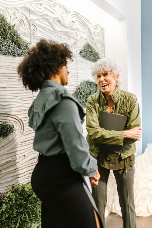 Free Two businesswomen, diverse in ethnicity, engaged in a lively conversation indoors, illustrating effective communication. Stock Photo