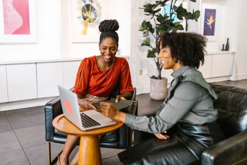 Free Two African American women collaborating on a business project in a modern office setting. Stock Photo
