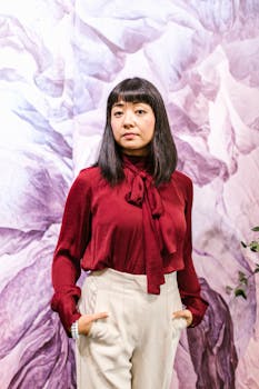 Portrait of a businesswoman in stylish burgundy top with a confident pose indoors.