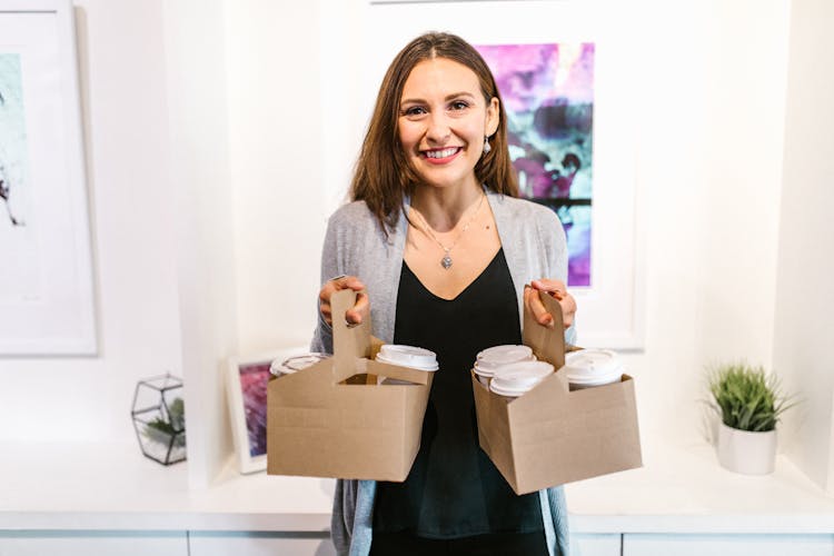 A Woman Carrying Cups Of Coffee