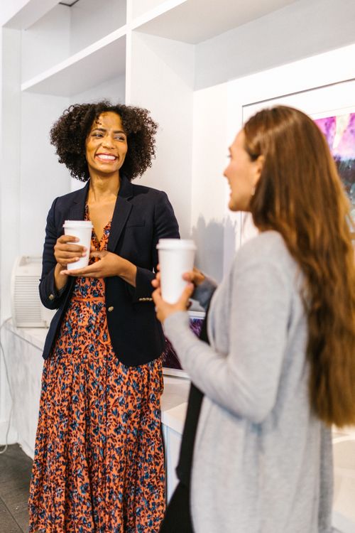 Free Two women enjoy a lively conversation with coffee in a business setting. Stock Photo