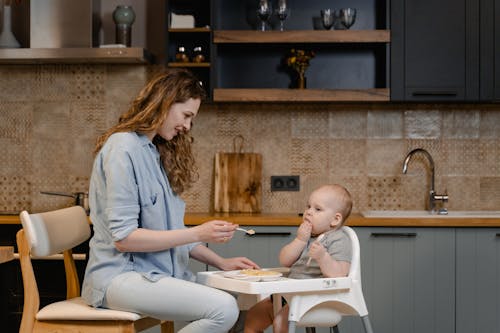 Free Mother Happily Feeding her Child Stock Photo