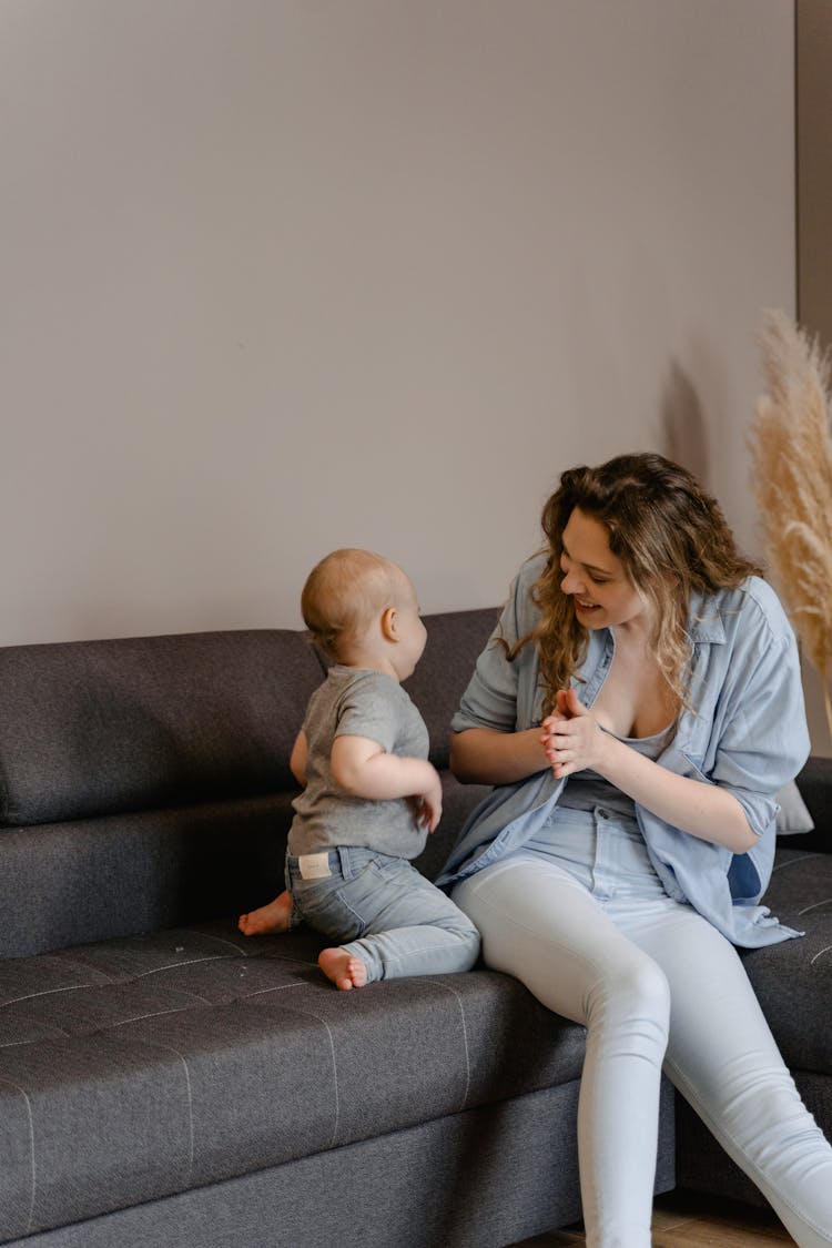 Woman Sitting On Gray Couch With Her Child