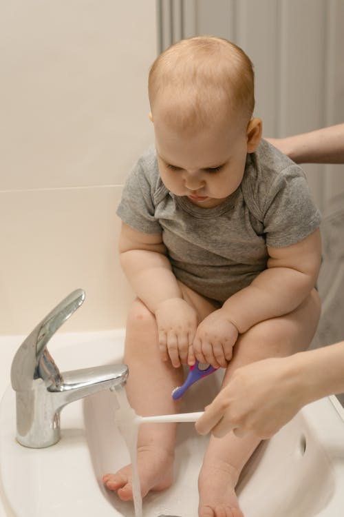 Cute Baby Sitting on the Edge of Lavatory