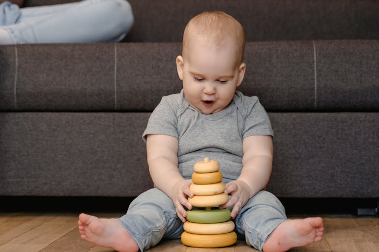 A Baby Playing With A Stacking Toy