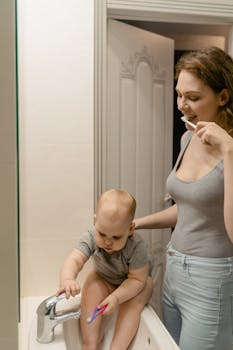 A joyful moment of bonding as a mother and baby brush their teeth together at home.