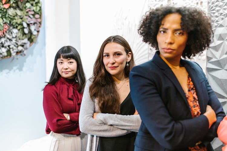 A Group Of Women In Business Attire With Their Arms Crossed