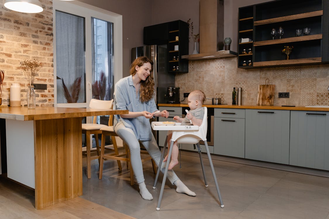 A Mother Feeding a Baby in kitchen