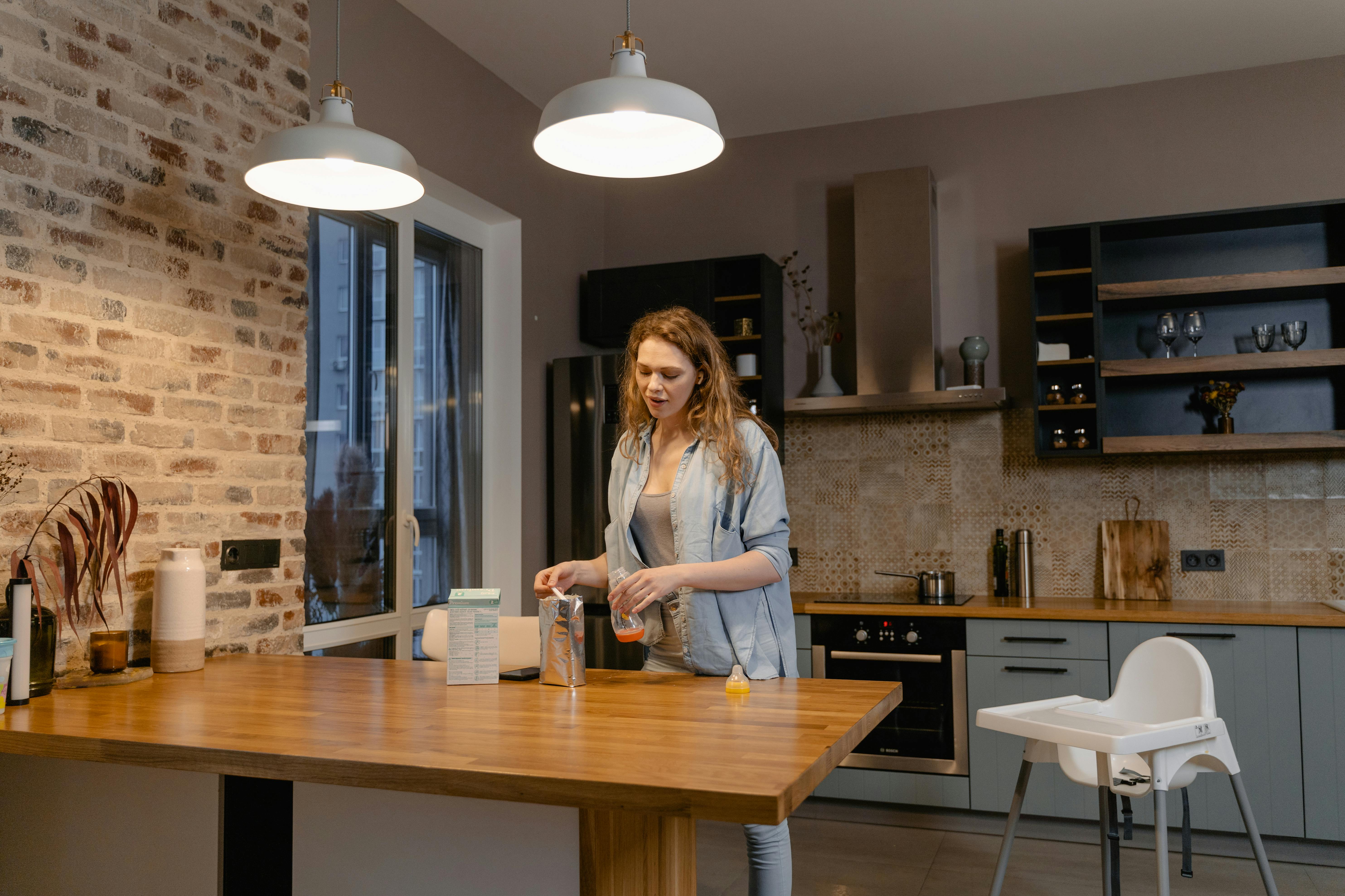 woman in white long sleeve shirt standing beside brown wooden table