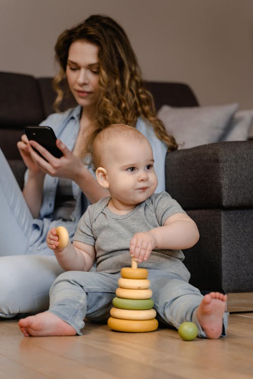 Free Woman and Her Child Sitting on the Floor Stock Photo