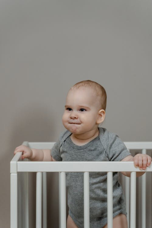 A Child Standing in the Crib