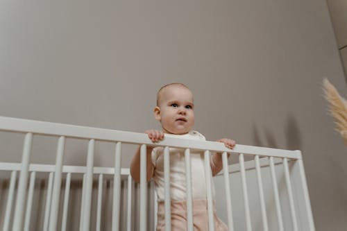 Low Angle Shot of Toddler on a Crib 