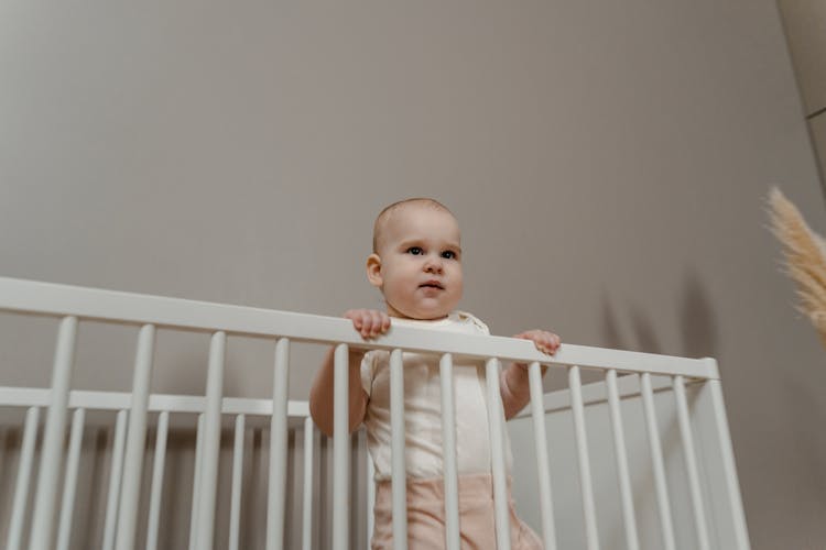 Low Angle Shot Of Toddler On A Crib 