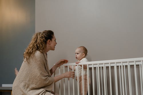 Free Mother Playing with her Child on Crib  Stock Photo