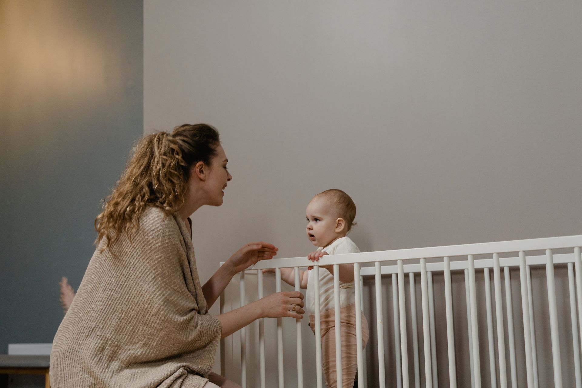 A mother shares a bonding moment with her baby in a cozy nursery setting.