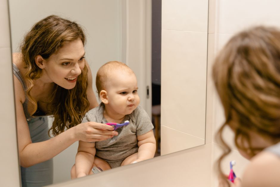 parent and toddler practicing tooth brushing in front of a mirror parent and toddler practicing tooth brushing in front of a mirror