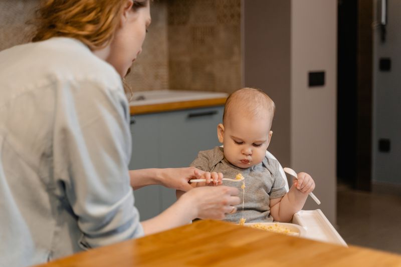 Mother feeding her child at the table