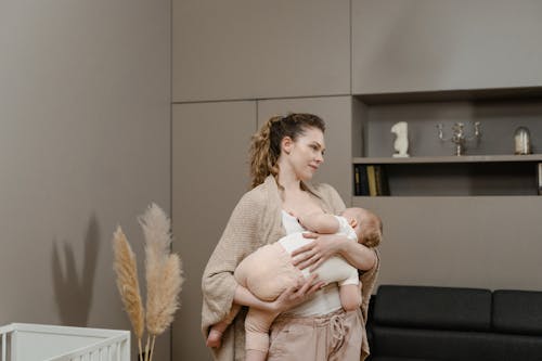 бесплатная Женщина в белой кружевной рубашке с длинным рукавом с младенцем Стоковое фото