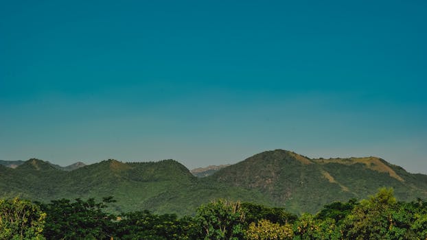 Vibrant green mountains under a bright blue sky, showcasing stunning natural beauty.