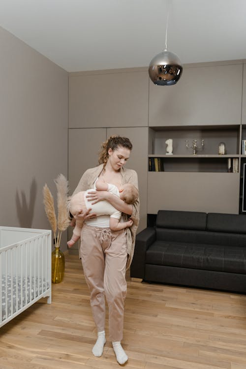 Free Woman Carrying a Baby Beside the Crib 




 Stock Photo