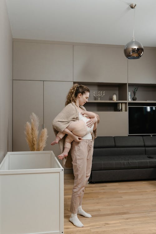 Free Photo of a Mother Breastfeeding Her Baby at the Living Room Stock Photo