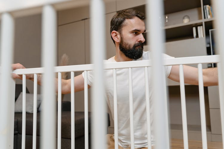 A Man With A Beard Building A Crib