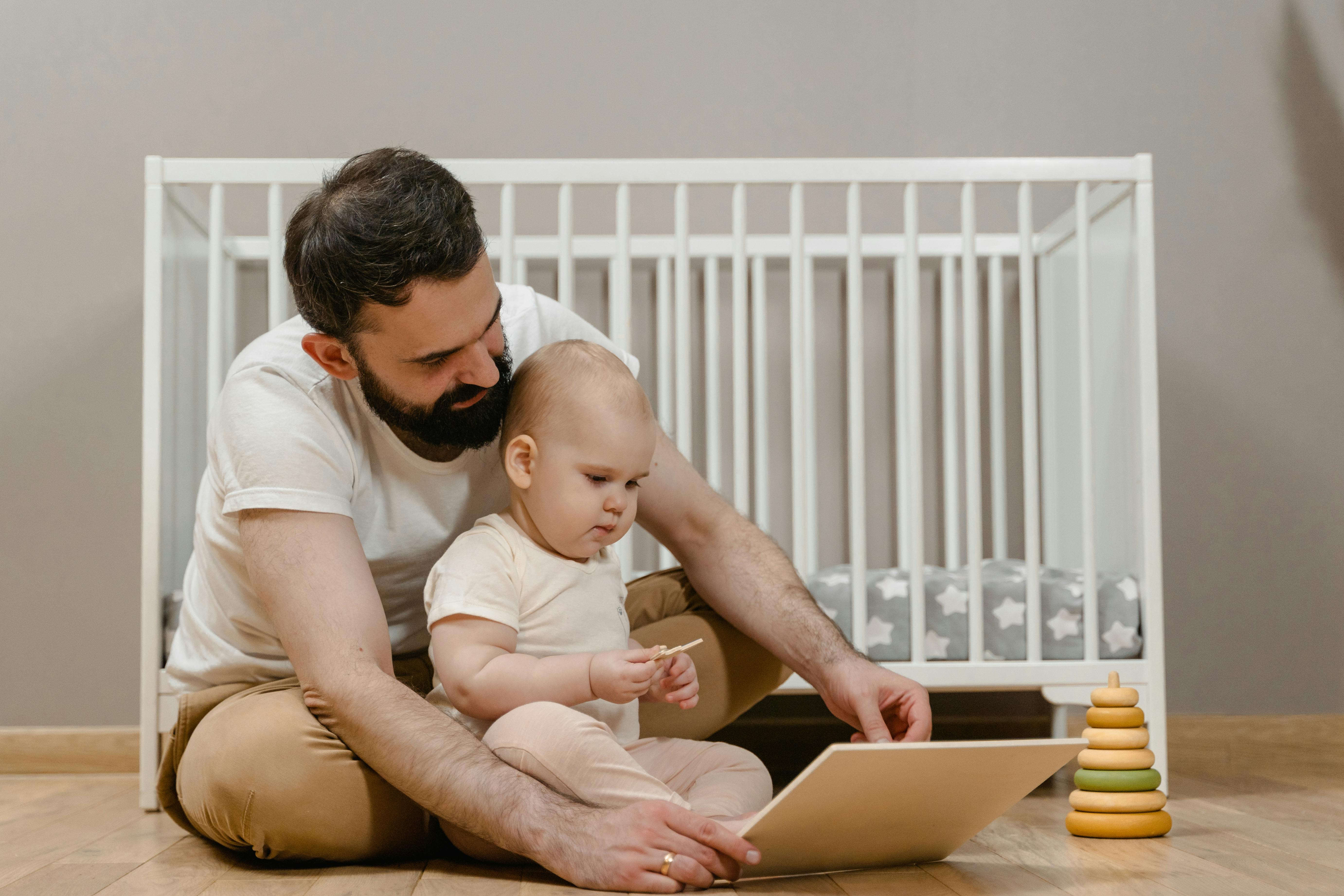 a man sitting with his baby on the floor