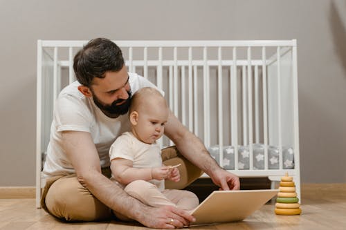 Free A Man Sitting with His Baby on the Floor Stock Photo