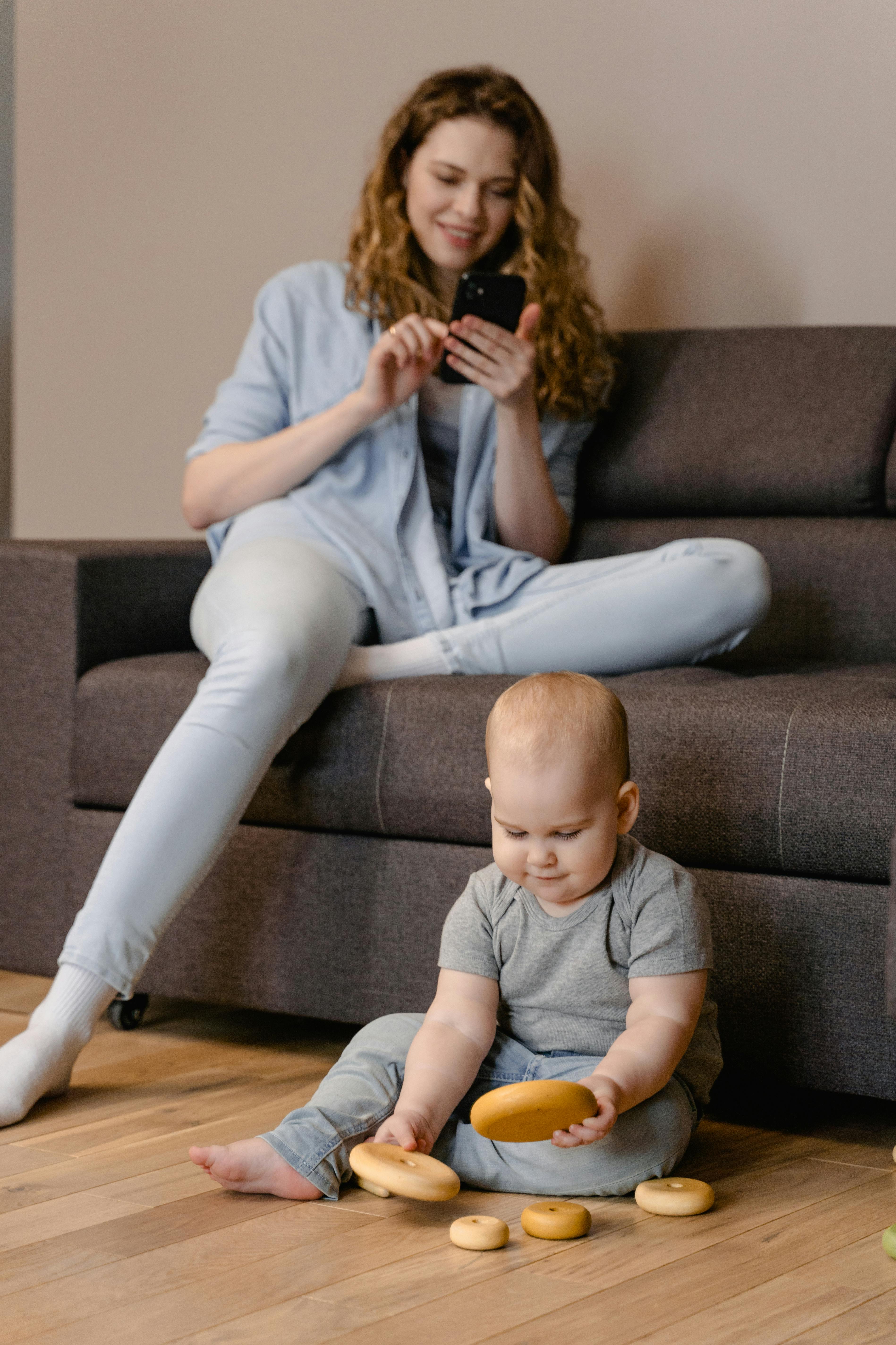 woman in gray long sleeve shirt and white pants sitting on brown couch