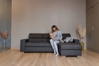 Woman in White Shirt Sitting on Gray Couch