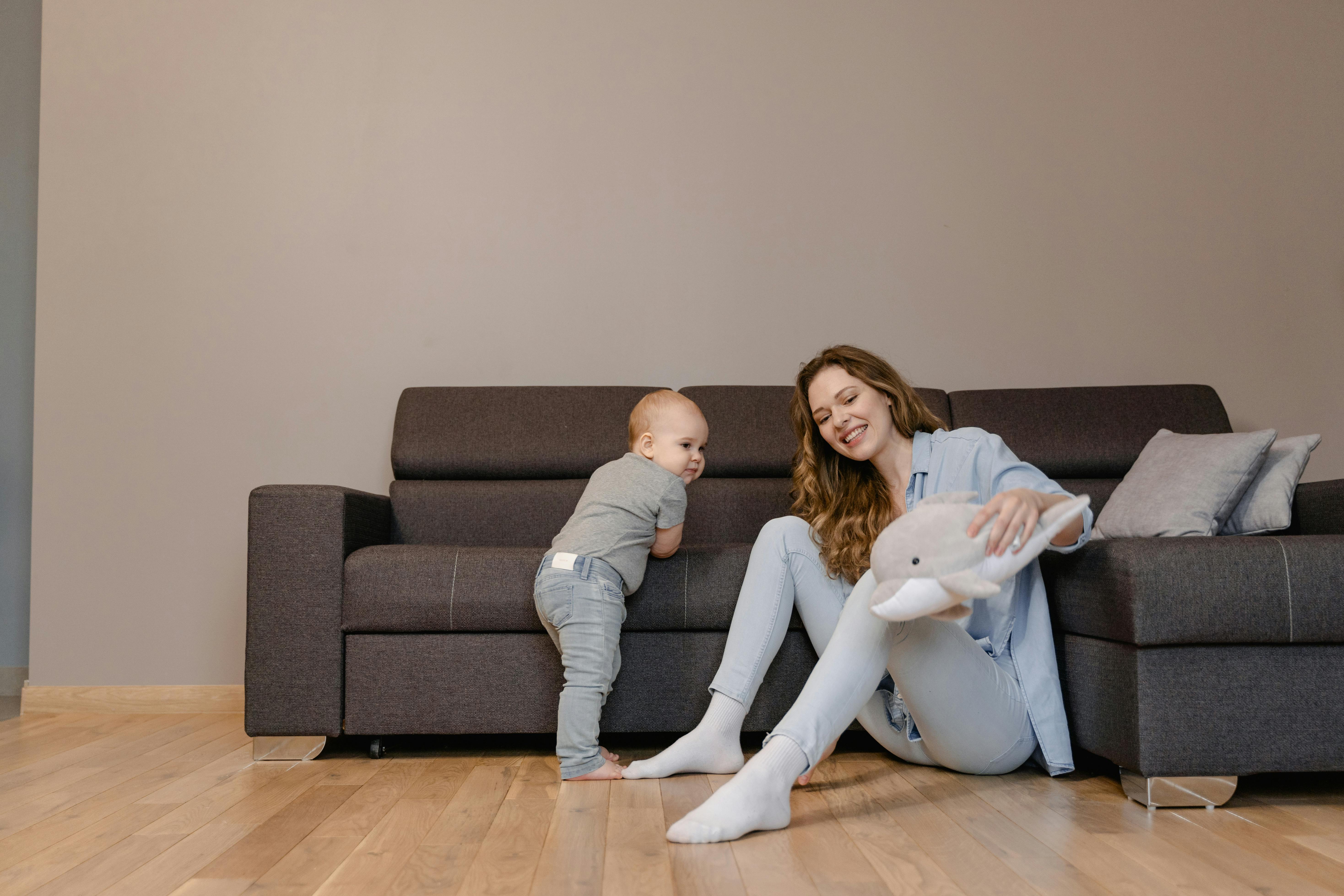 A joyful mother and her baby playing together on the living room floor, creating tender family moments.